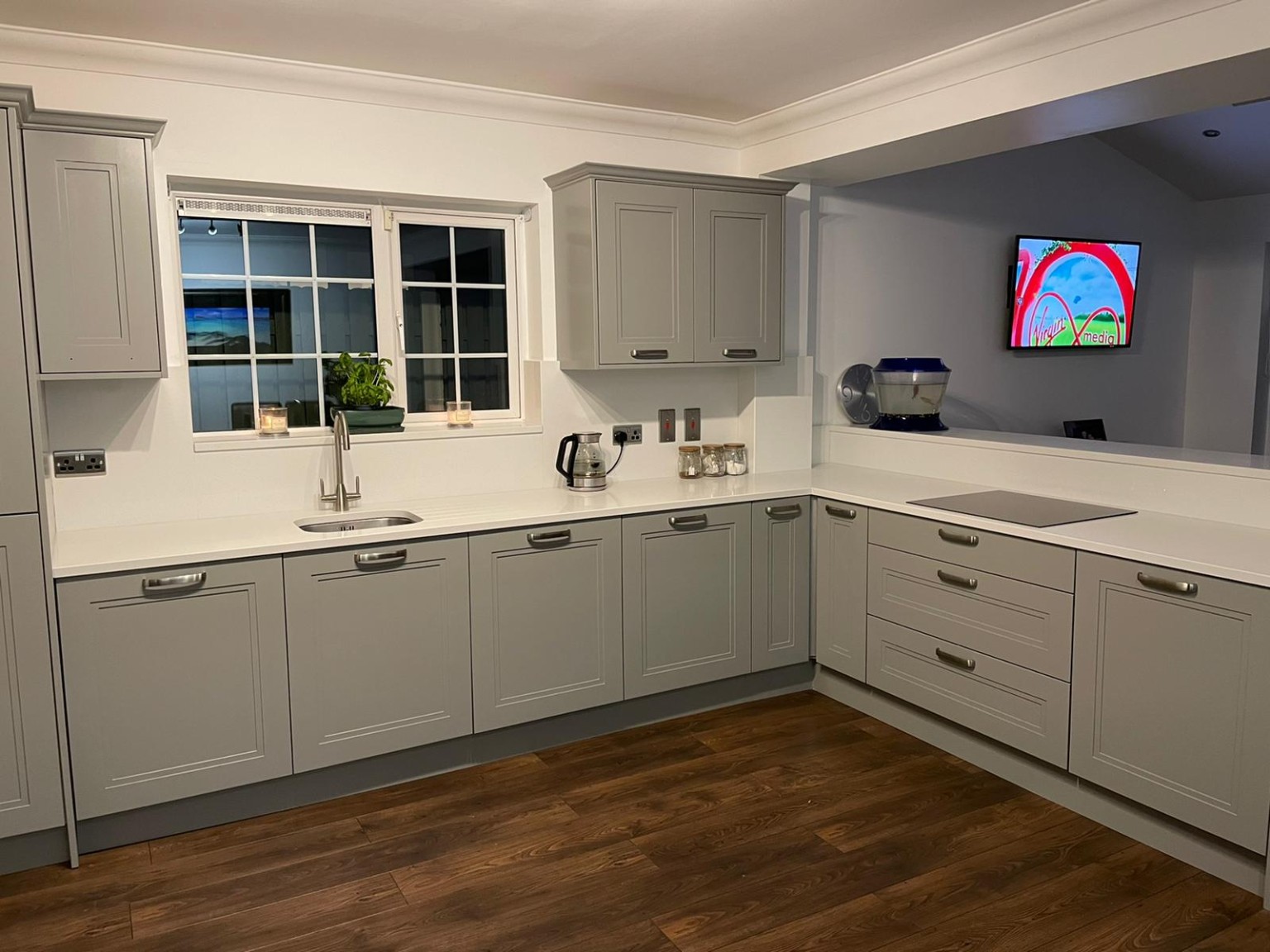 Bespoke grey Shaker-style L-shaped kitchen with integrated storage by A&A Design.